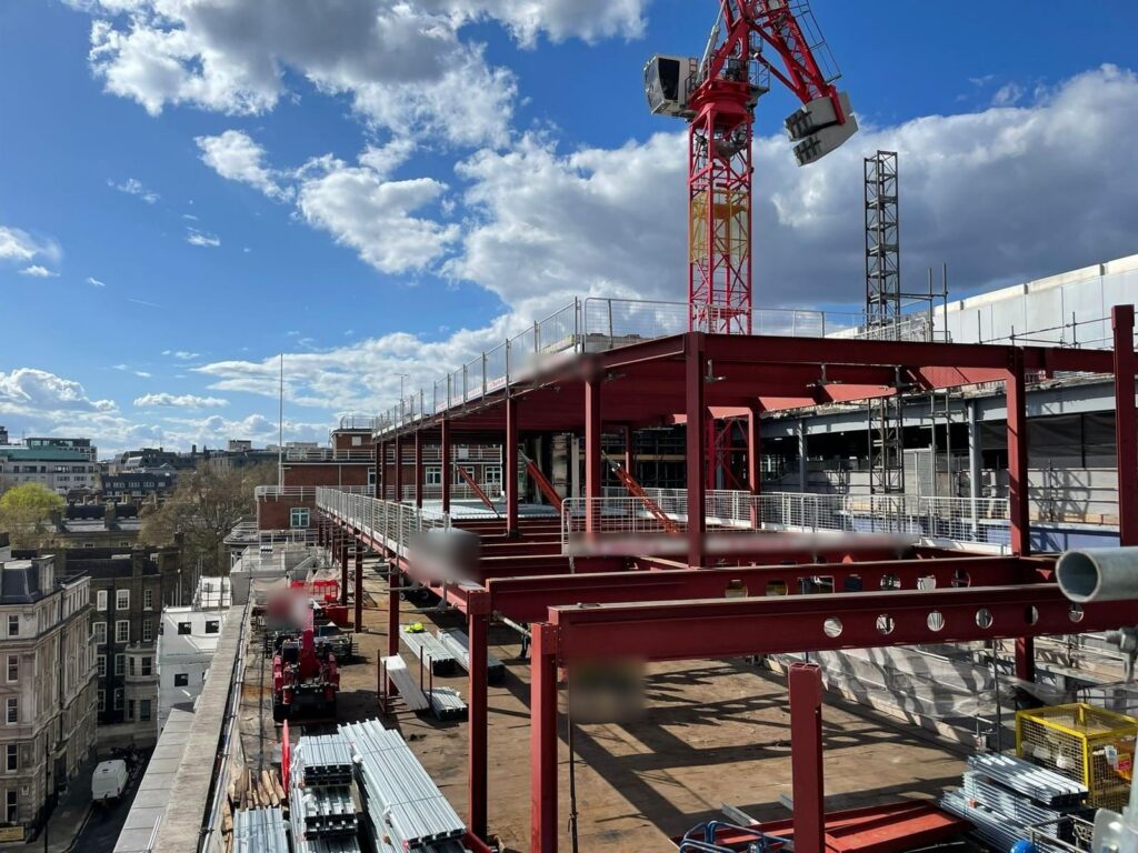 The tower crane lifting steel onto the roof